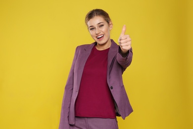 Photo of Happy young businesswoman showing thumb up gesture on color background. Celebrating victory