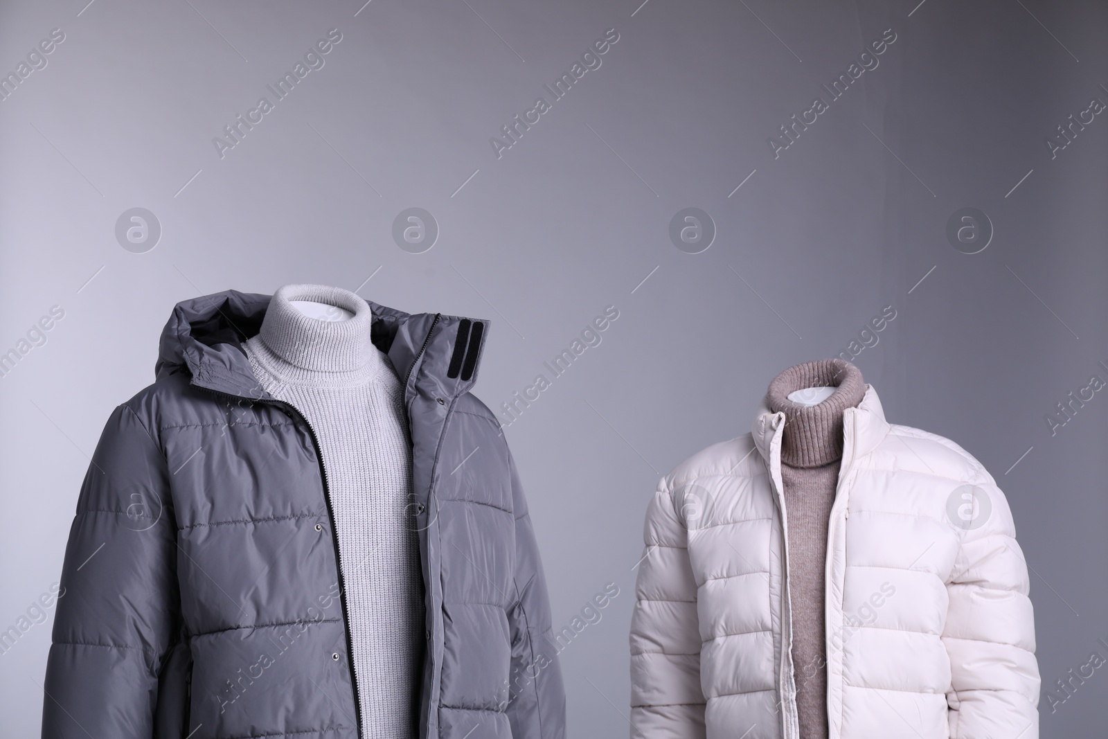 Photo of Male and female mannequins dressed in stylish outfits on grey background