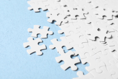 Photo of Blank white puzzle pieces on light blue background