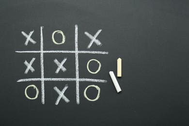 Tic tac toe game drawn on chalkboard, top view