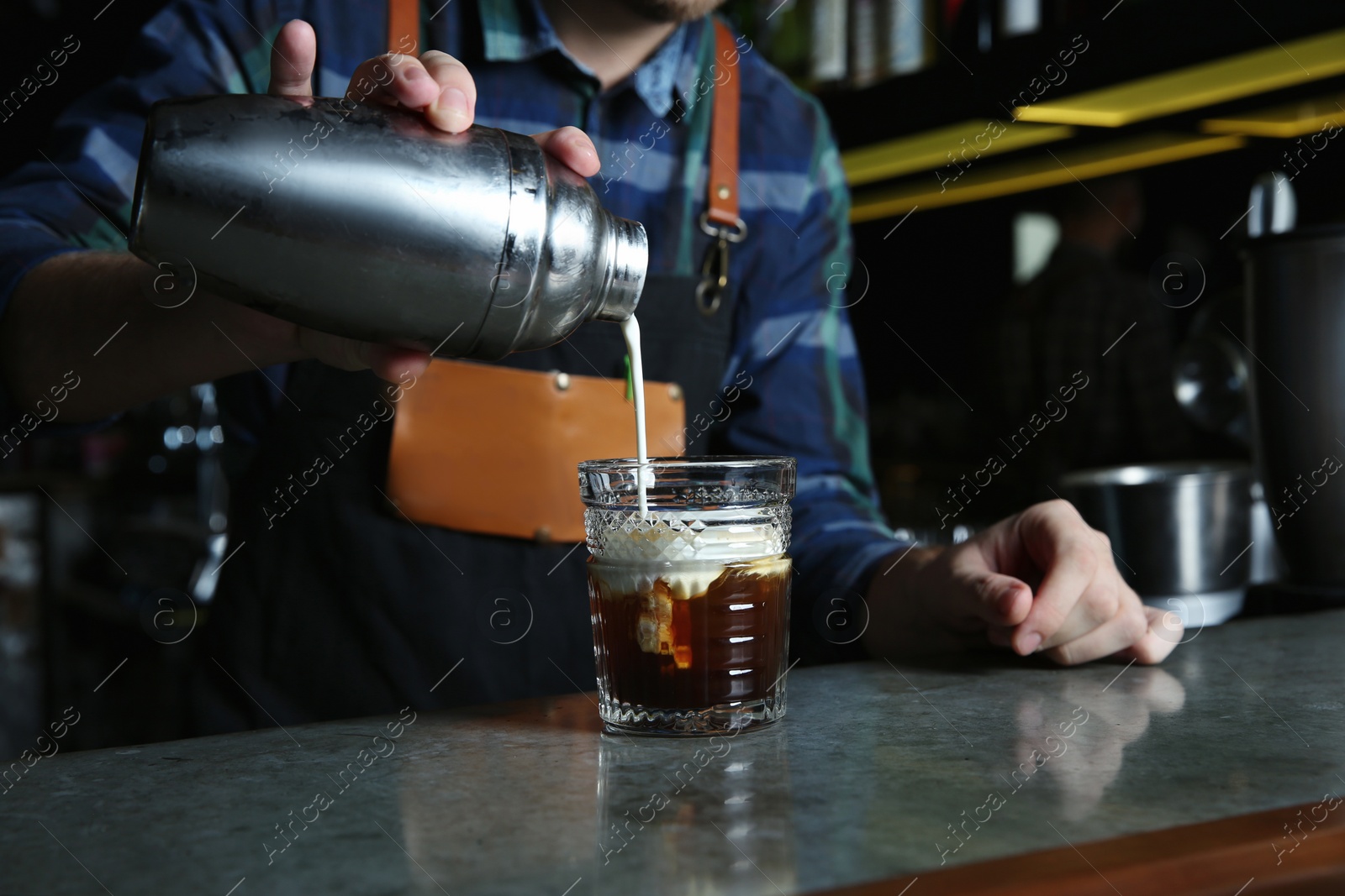 Photo of Barman making White Russian cocktail at counter in pub, closeup. Space for text