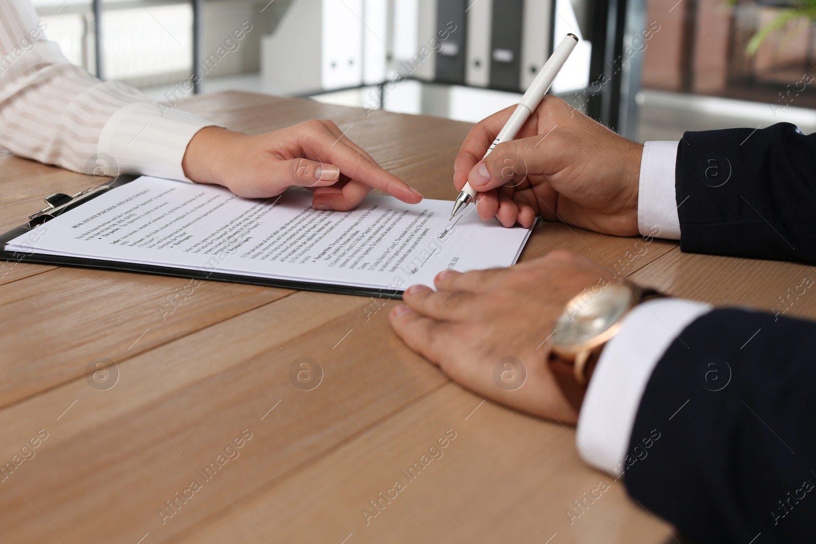 Photo of People working with Real Estate Purchase And Sale Contract at table indoors, closeup