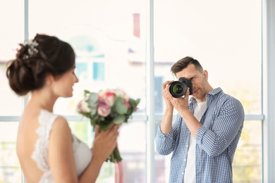 Photo of Professional photographer taking photo of beautiful bride in studio