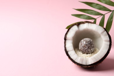 Photo of Composition with delicious vegan candy ball and coconut on pink background. Space for text