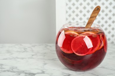 Photo of Glass bowl of aromatic punch drink on white marble table, space for text