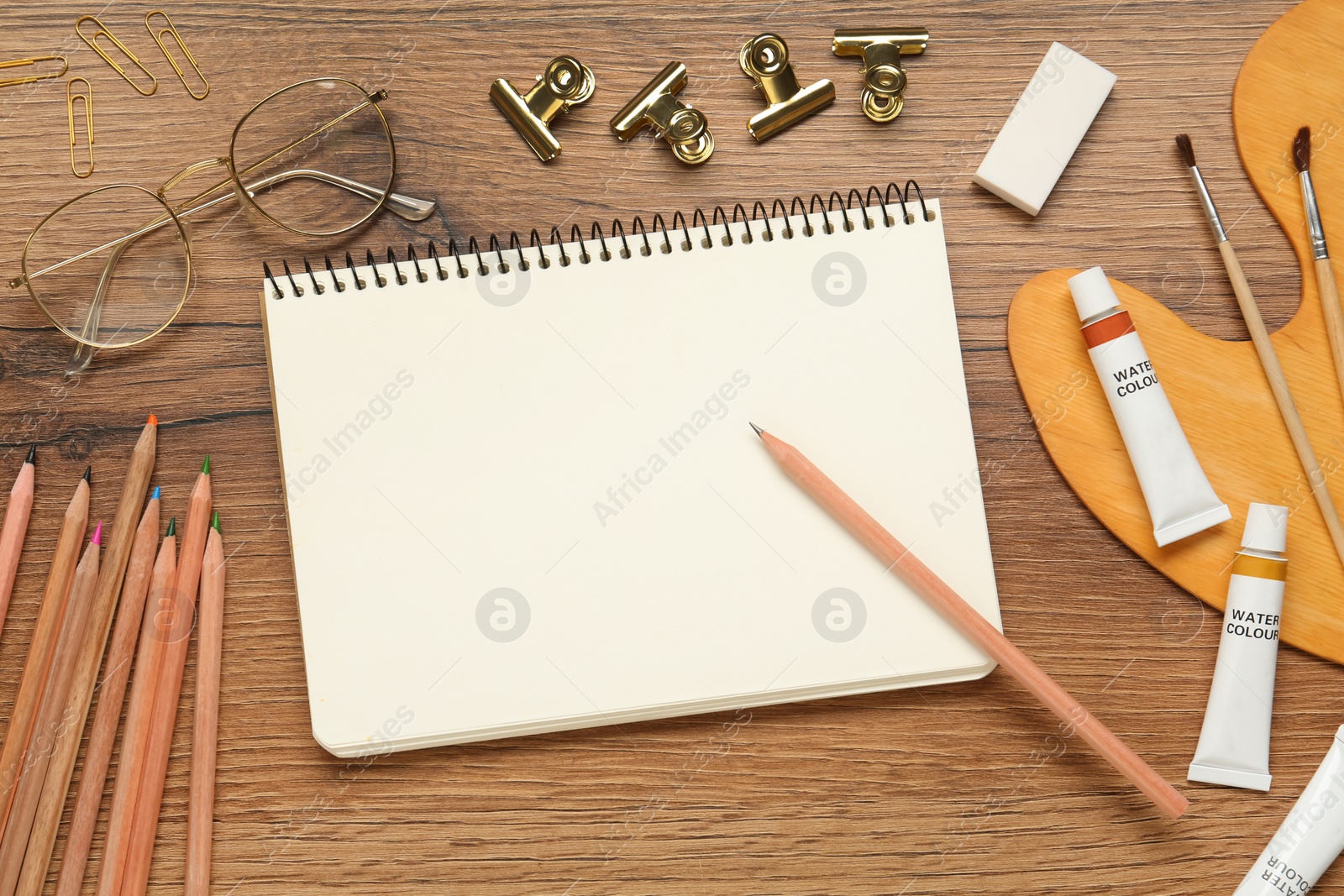 Photo of Flat lay composition with blank sketchbook on wooden table. Space for text