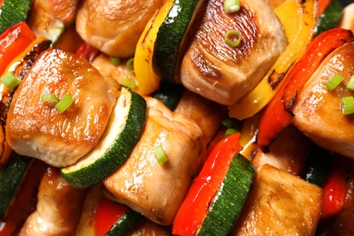 Photo of Delicious chicken shish kebabs with vegetables on plate, top view