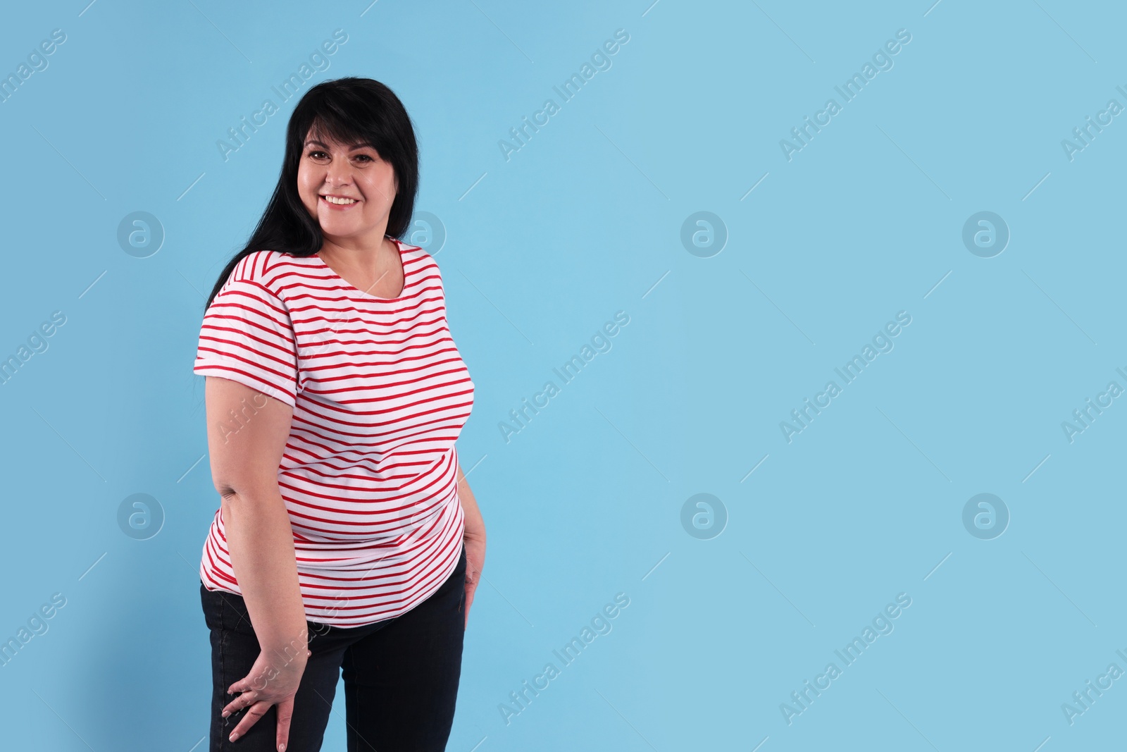 Photo of Beautiful overweight mature woman with charming smile on turquoise background. Space for text