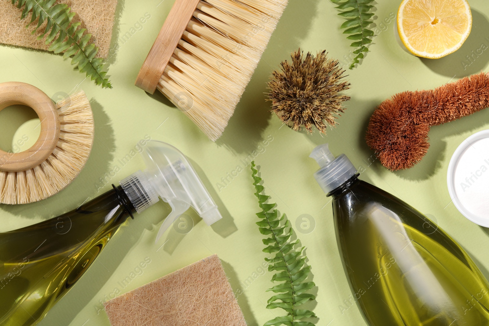 Photo of Flat lay composition with different cleaning supplies on green background