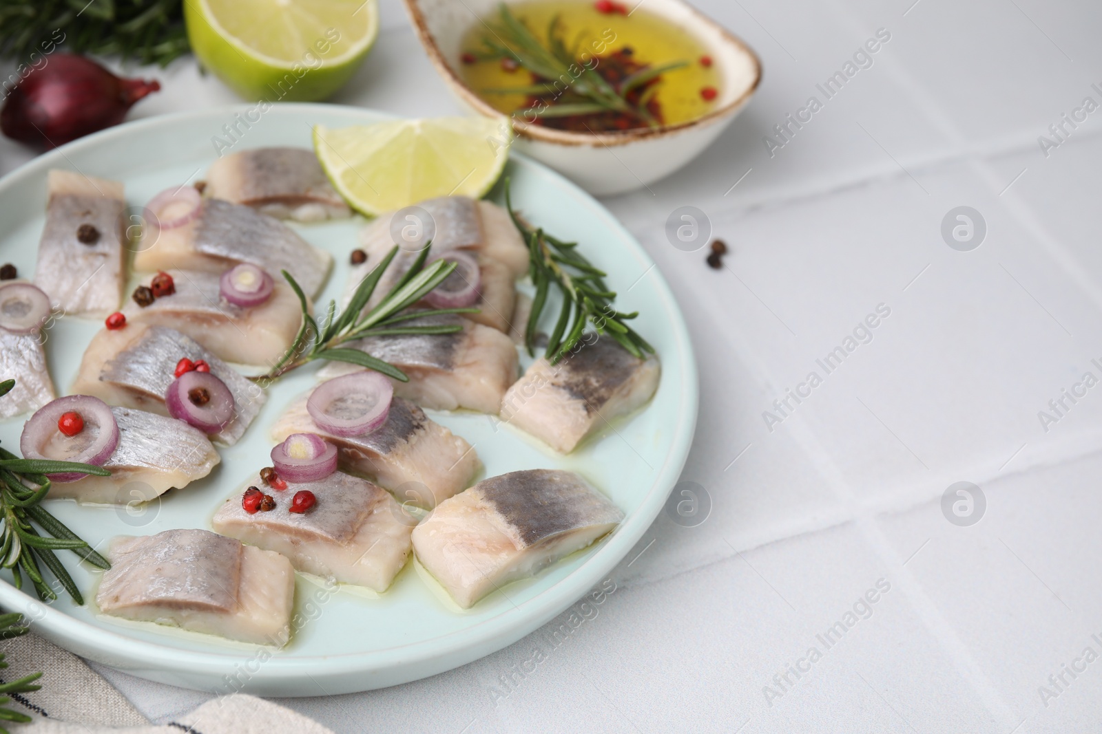 Photo of Tasty marinated fish with rosemary and spices on light tiled table, closeup. Space for text