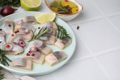 Photo of Tasty marinated fish with rosemary and spices on light tiled table, closeup. Space for text