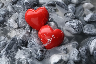 Red decorative hearts on stones and water