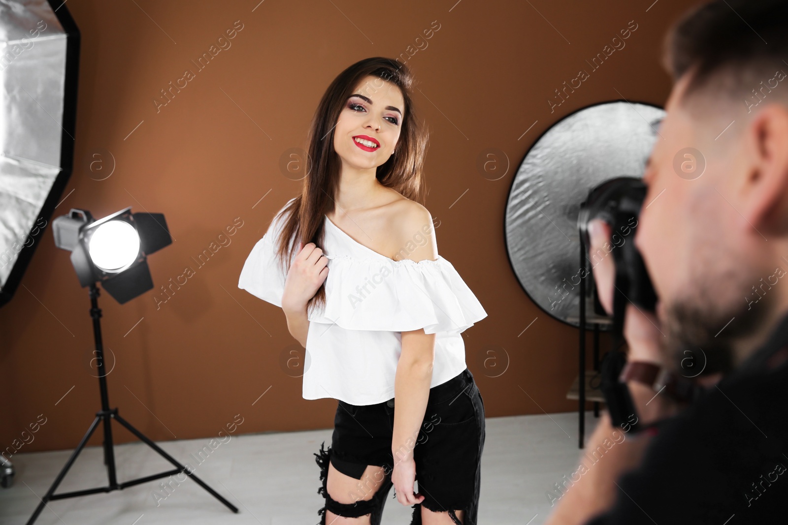 Photo of Beautiful young model posing for professional photographer in studio