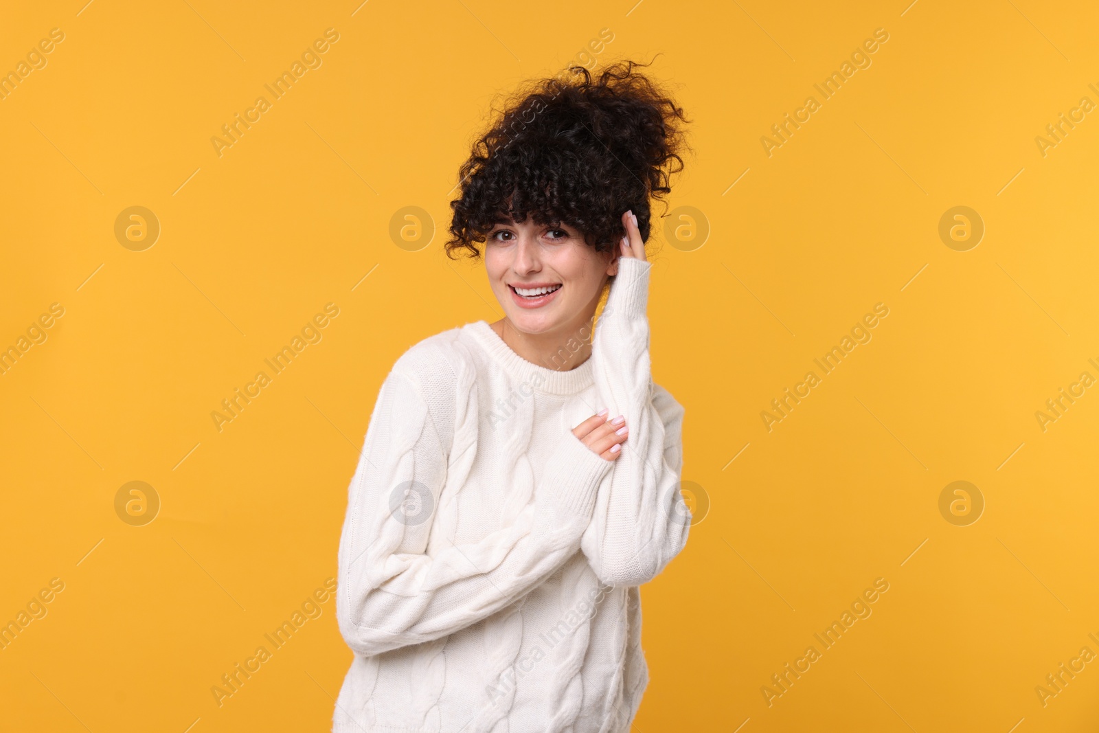 Photo of Happy young woman in stylish white sweater on yellow background