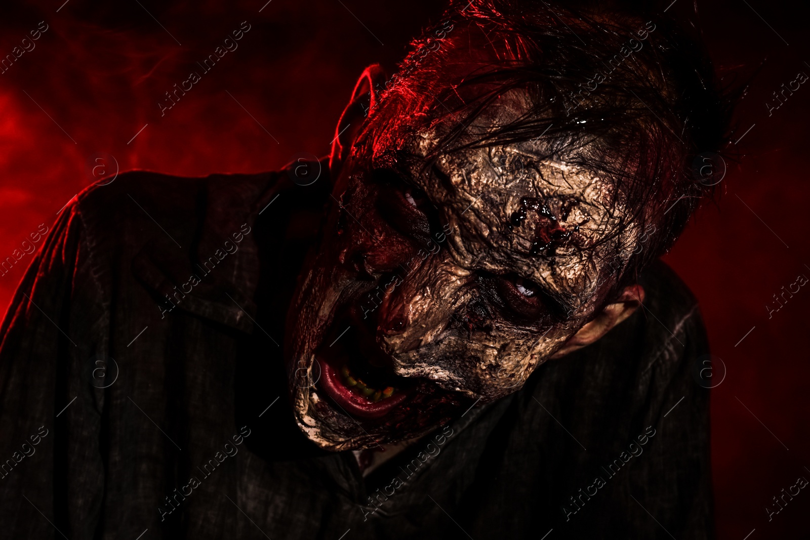 Photo of Scary zombie on dark background, closeup. Halloween monster