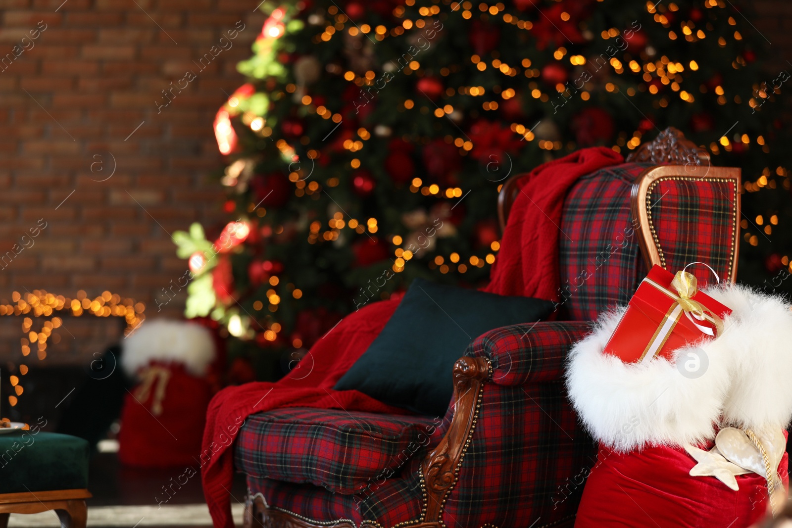 Photo of Santa Claus bag near armchair in room with Christmas tree