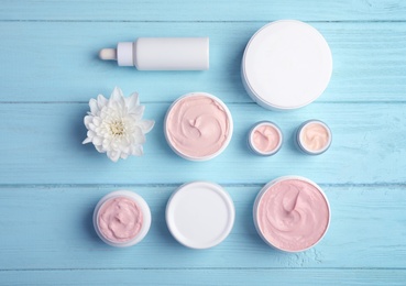 Photo of Flat lay composition with hand cream jars on wooden background