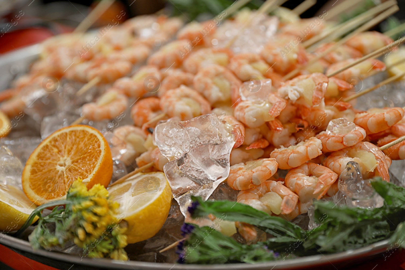 Photo of Shrimp skewers served in dish with ice, closeup