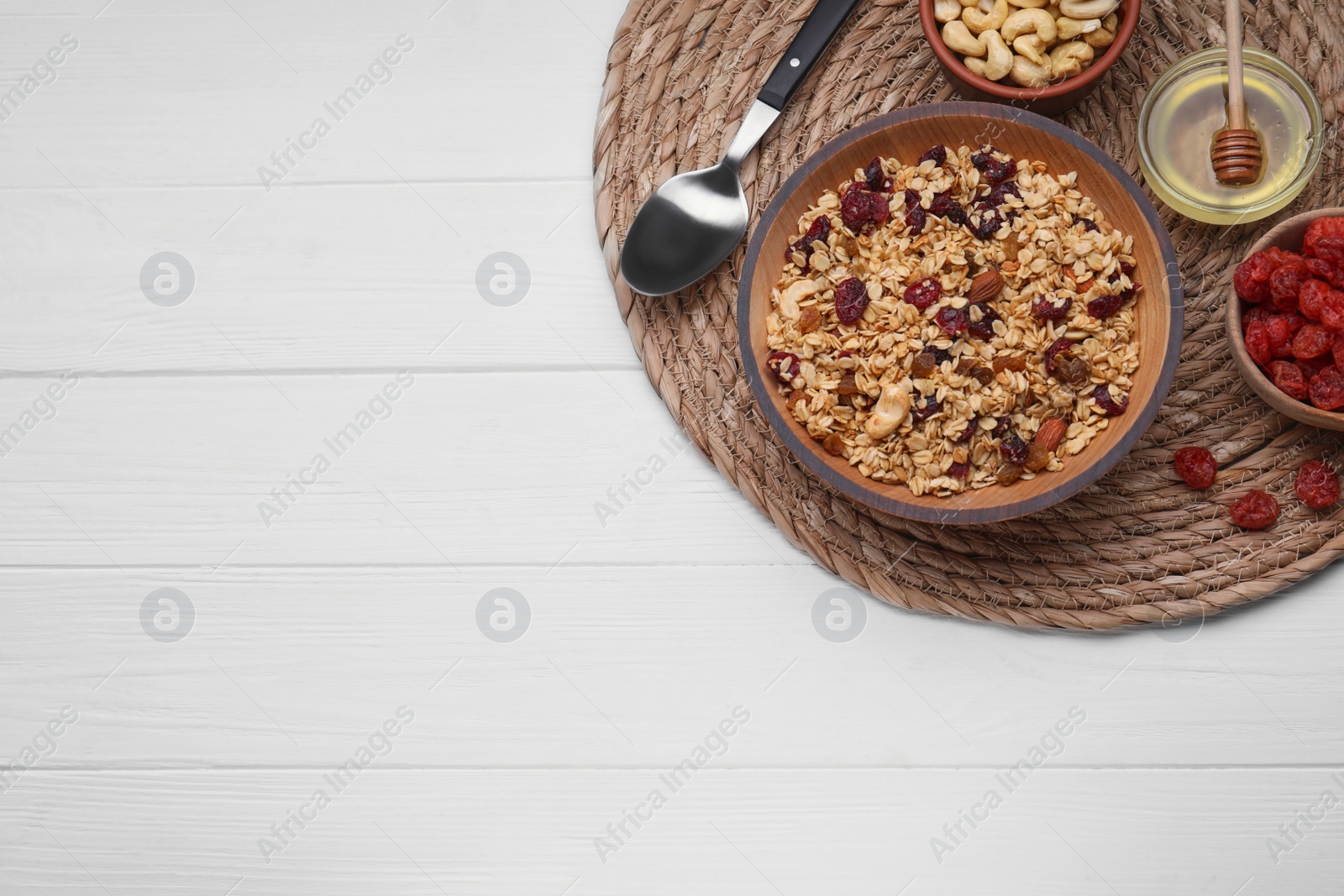 Photo of Tasty granola with nuts and dry fruits on white wooden table, flat lay. Space for text