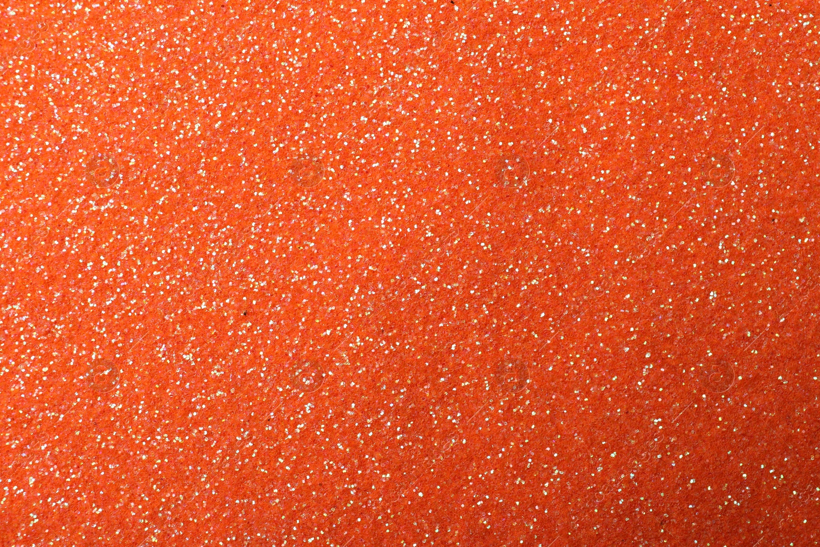 Photo of Beautiful shiny orange glitter as background, closeup