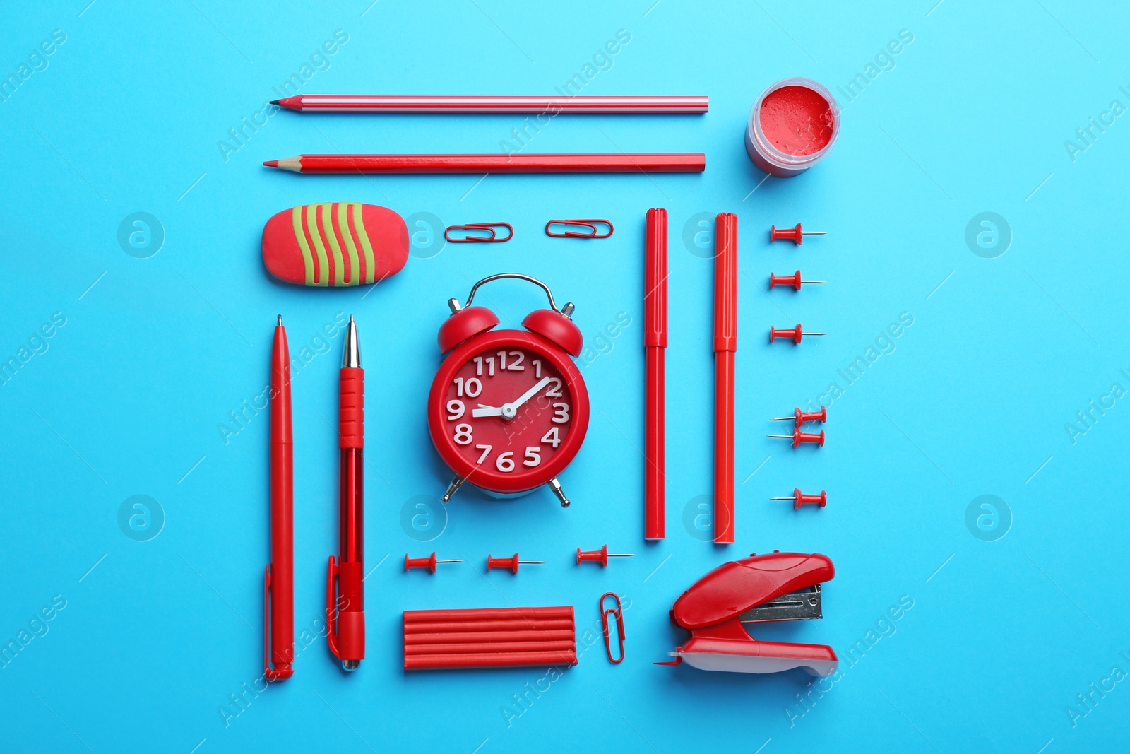 Photo of Red school stationery on light blue background, flat lay