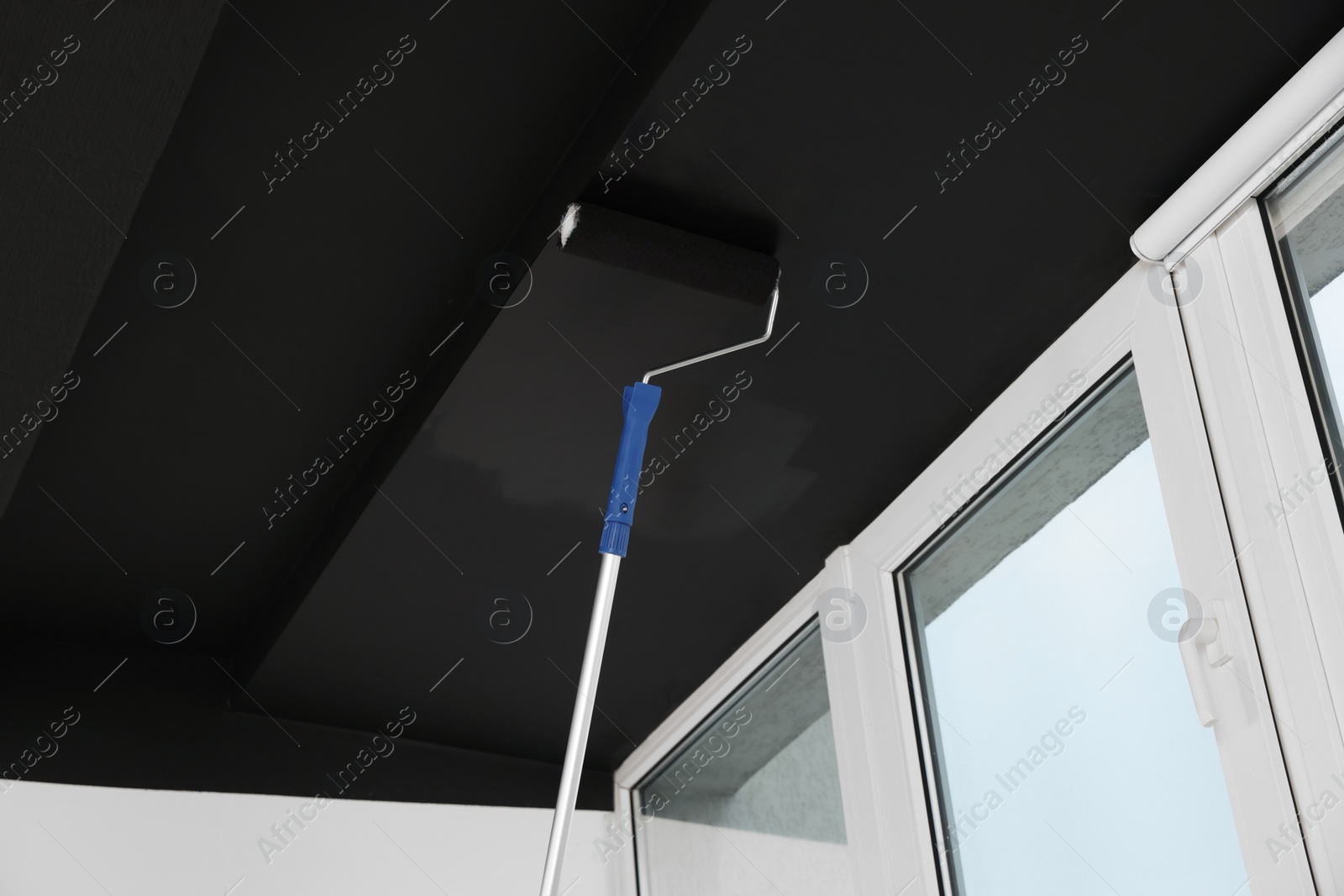 Photo of Painting ceiling with black dye indoors, low angle view