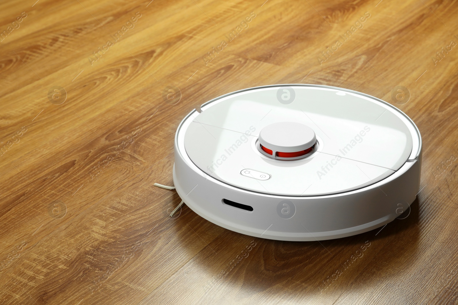 Photo of Robotic vacuum cleaner on wooden floor, space for text