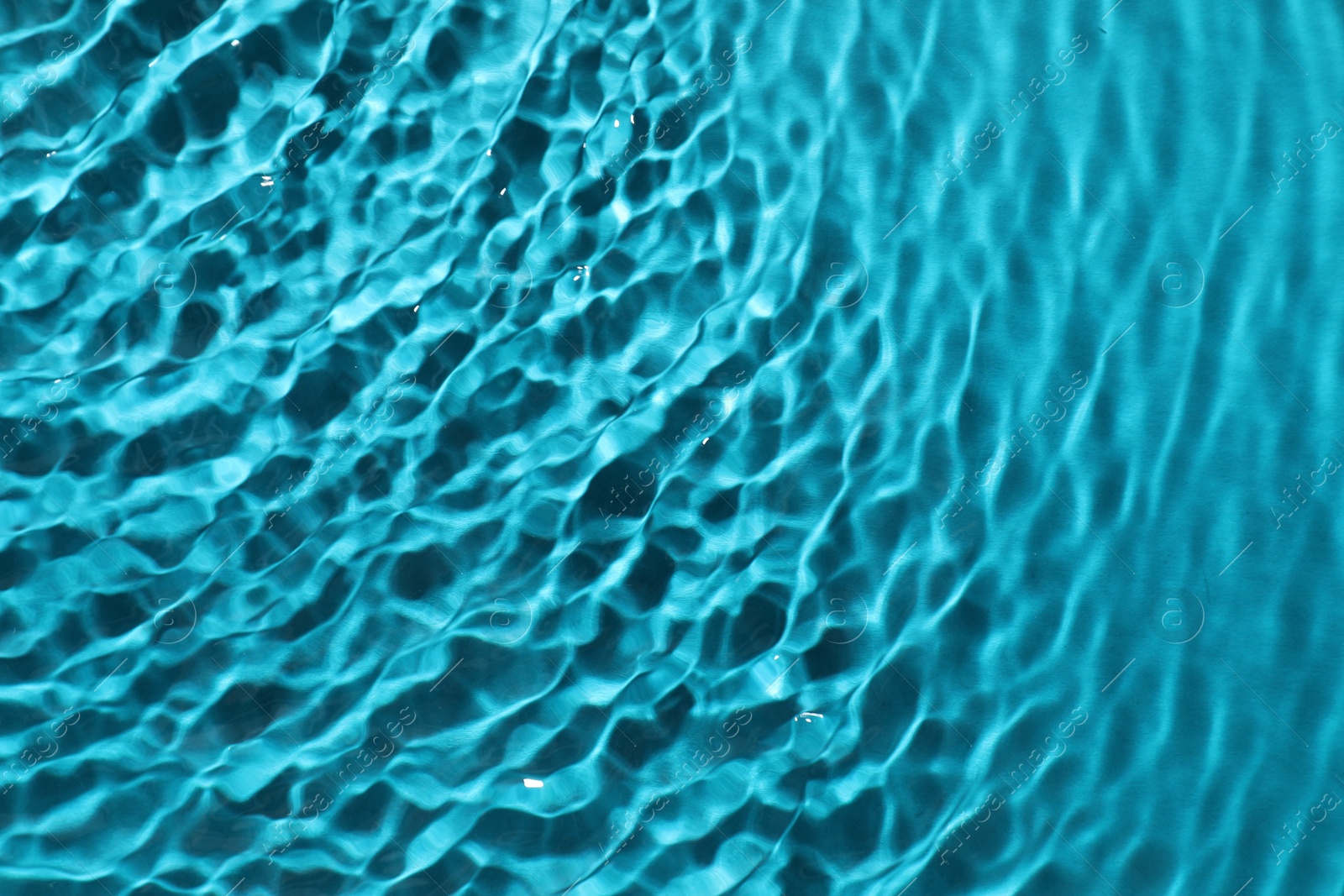 Photo of Rippled surface of clear water on light blue background, top view