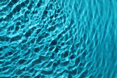 Rippled surface of clear water on light blue background, top view