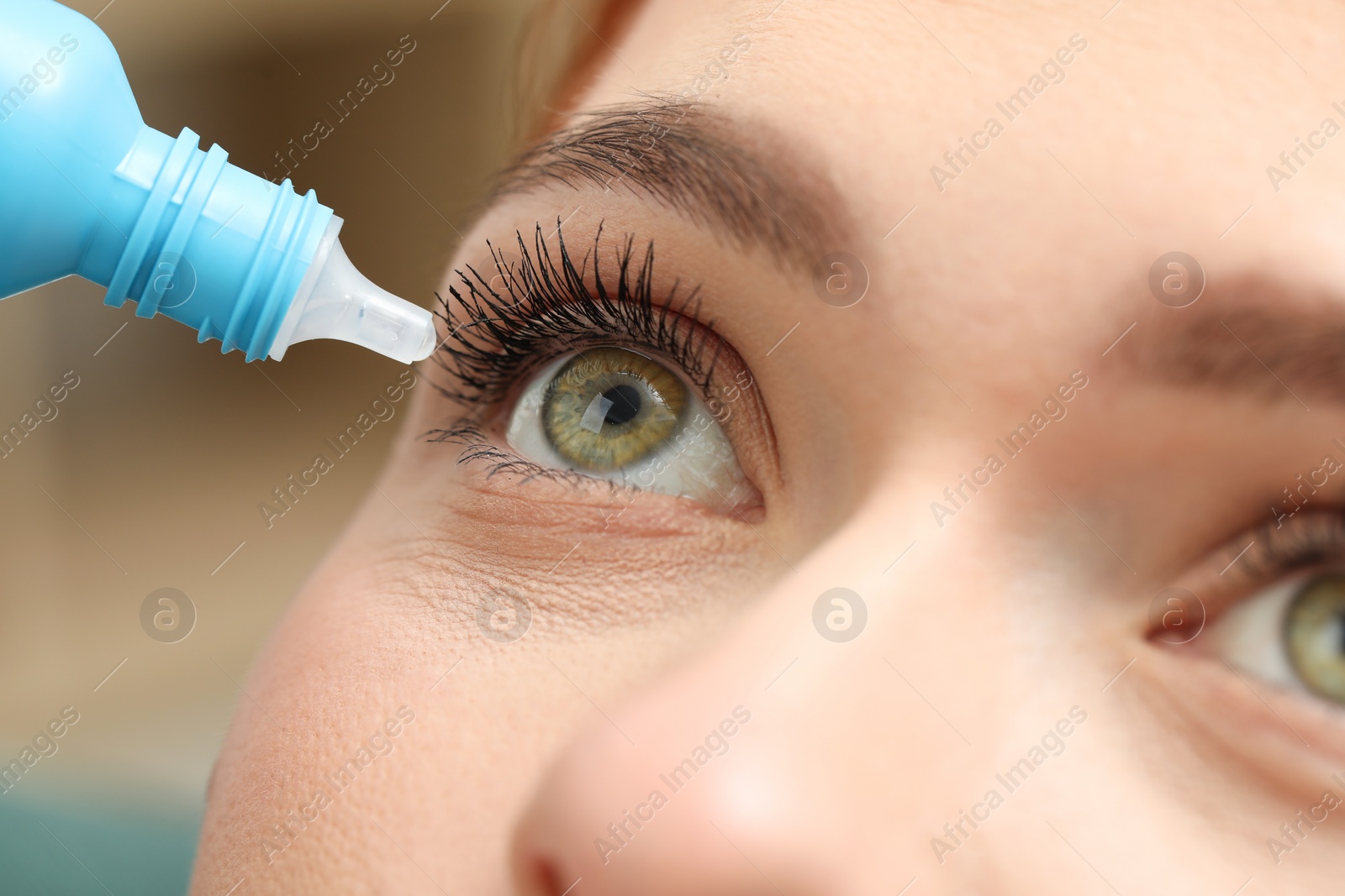 Photo of Woman applying medical eye drops, macro view