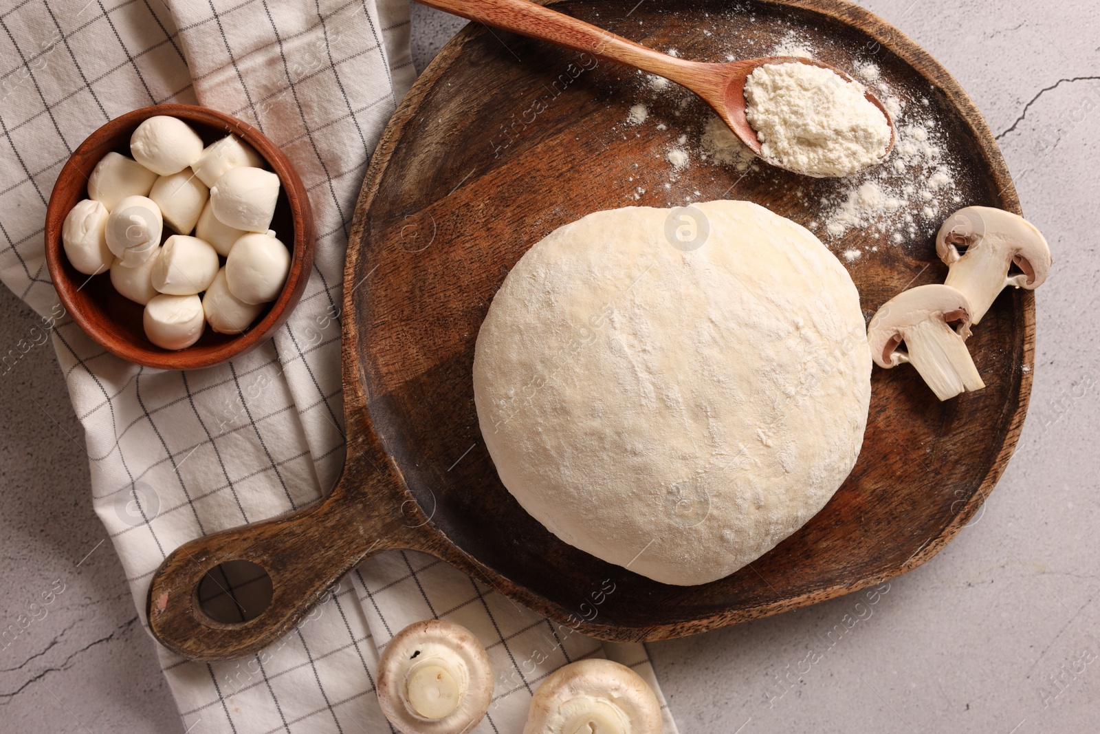 Photo of Pizza dough and products on gray textured table, flat lay