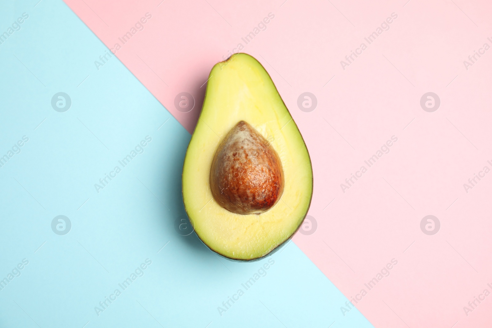 Photo of Cut fresh ripe avocado on color background, top view