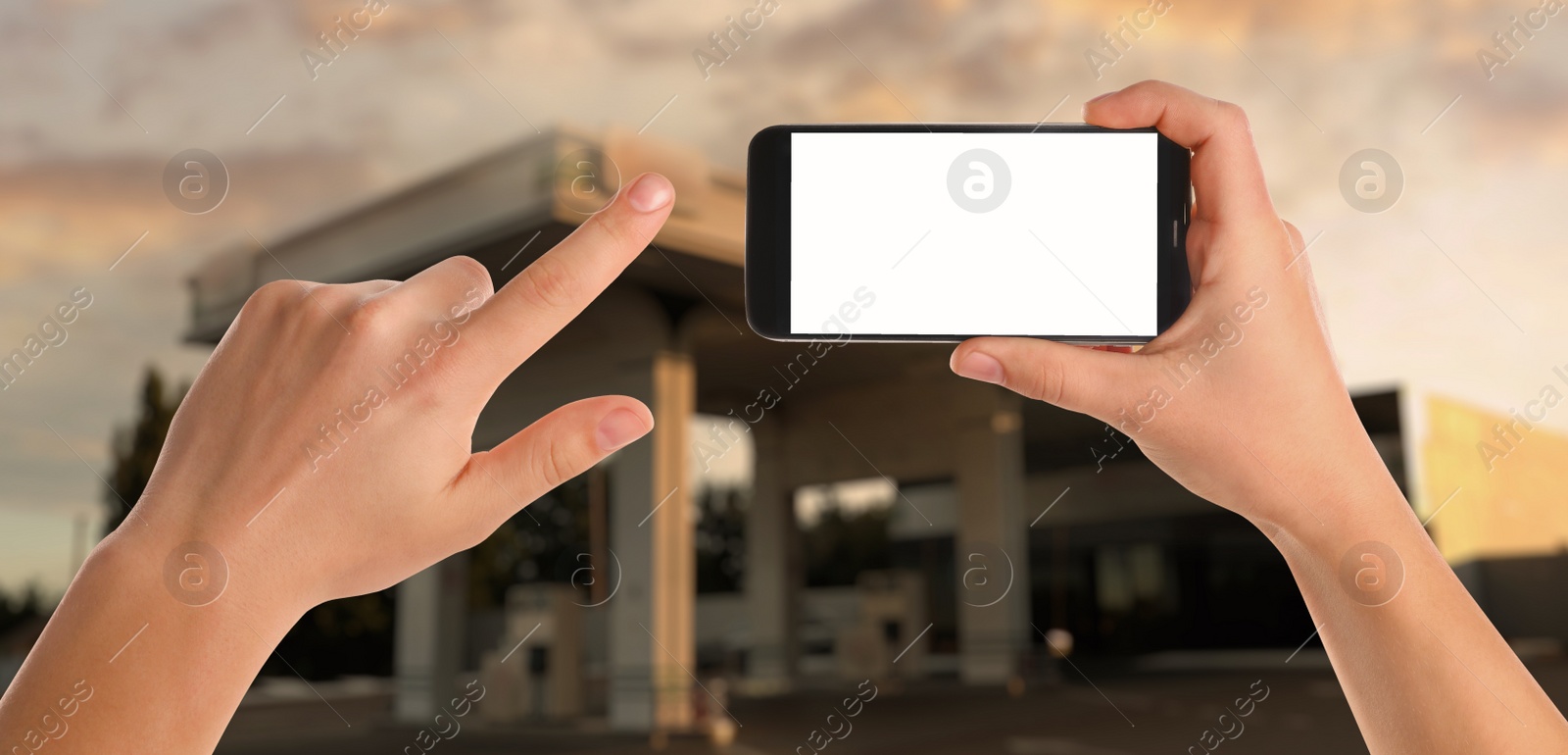 Image of Man paying for refueling via smartphone at gas station, closeup. Device with empty screen