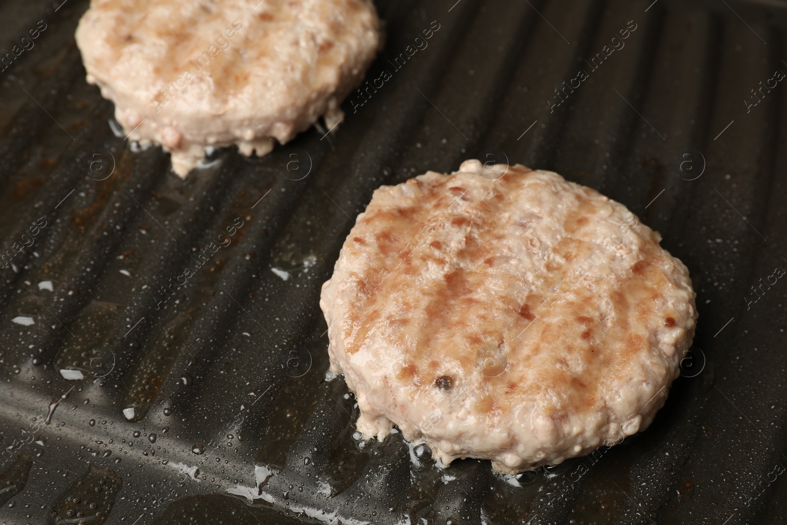 Photo of Cooking tasty hamburger patties on grill pan, closeup