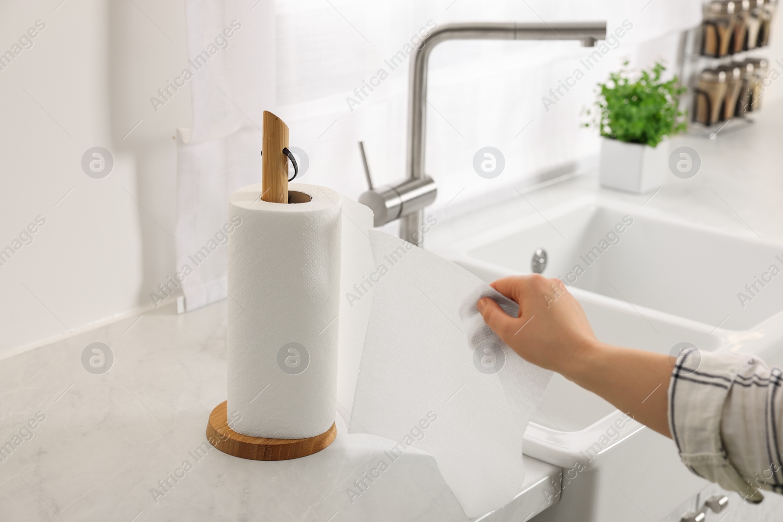 Photo of Woman using paper towels in kitchen, closeup