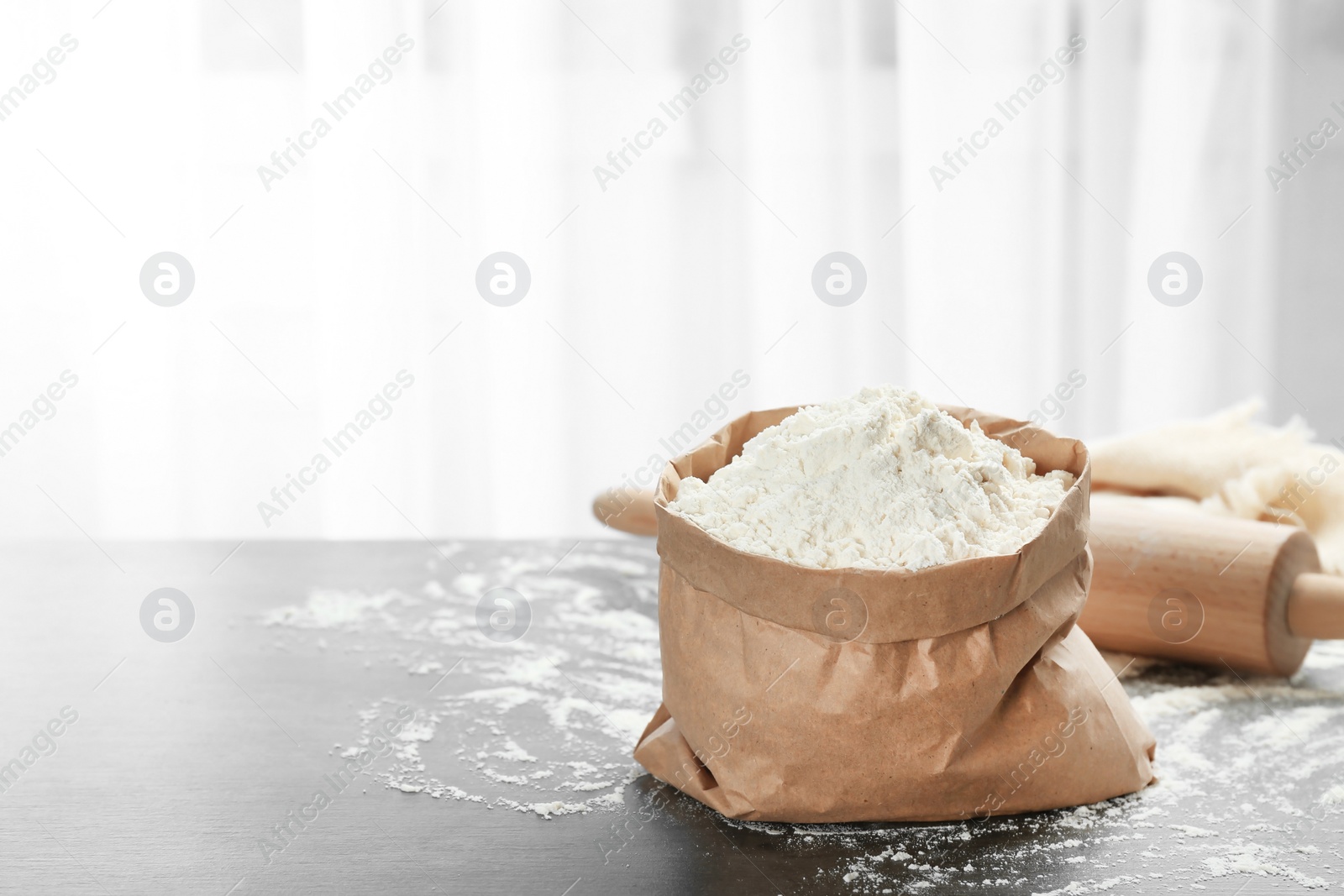 Photo of Paper bag with flour on kitchen table