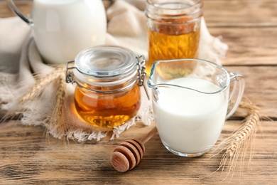 Photo of Beautiful composition with milk and honey on wooden background