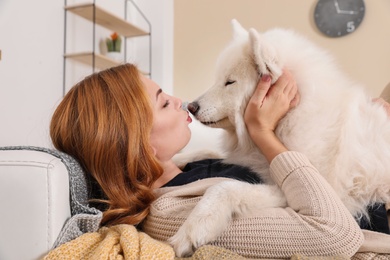 Photo of Beautiful woman with her dog lying on sofa at home
