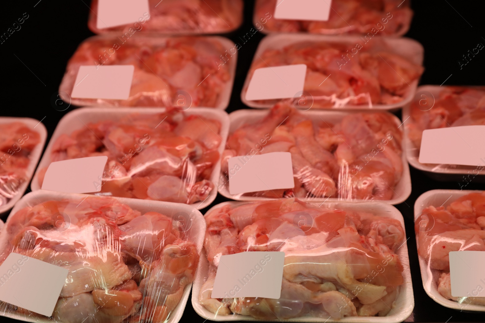 Photo of Shelf with packed chicken meat in supermarket