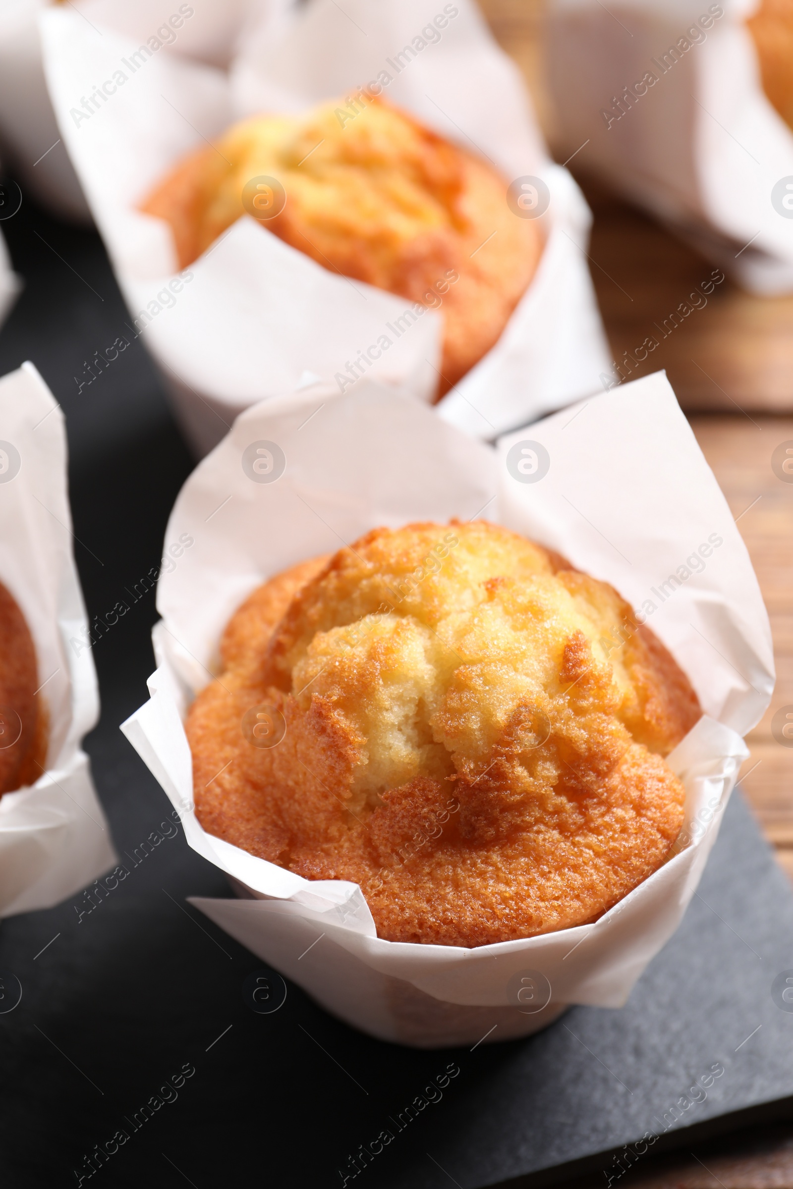 Photo of Delicious sweet muffins on wooden table, closeup. Space for text