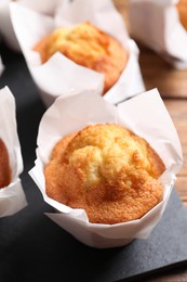 Delicious sweet muffins on wooden table, closeup. Space for text