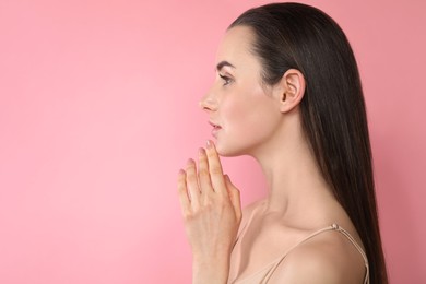 Portrait of beautiful young woman on pink background. Space for text