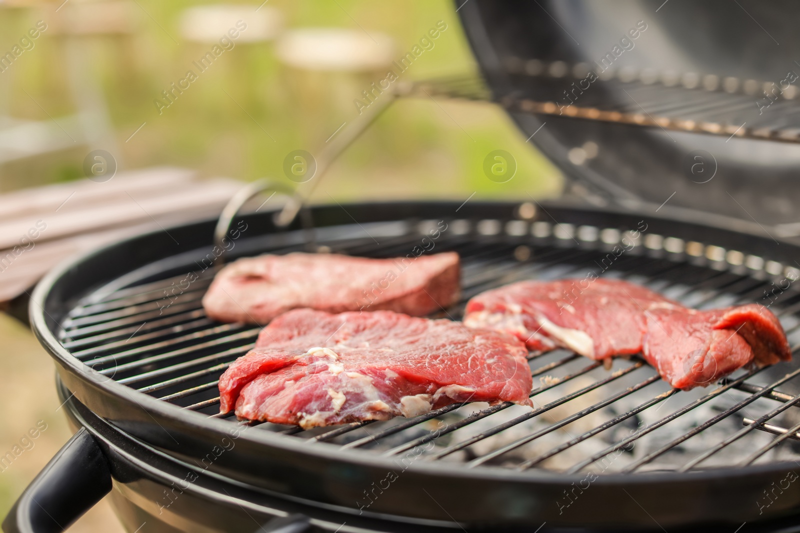 Photo of Tasty meat on barbecue grill outdoors, closeup