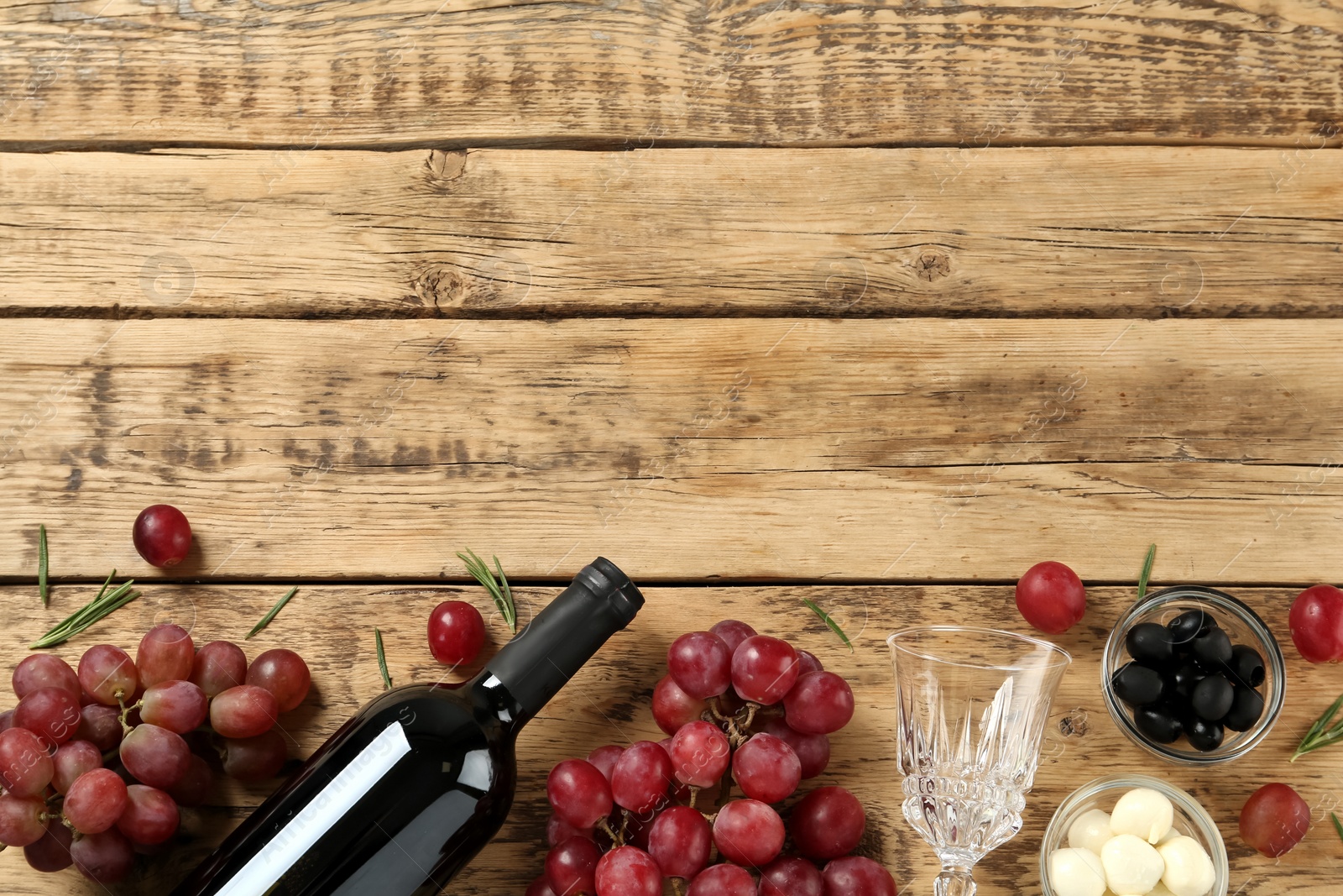 Photo of Flat lay composition with red wine and snacks on wooden table, space for text