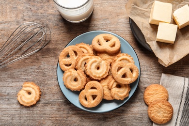 Plate with Danish butter cookies on wooden background, top view