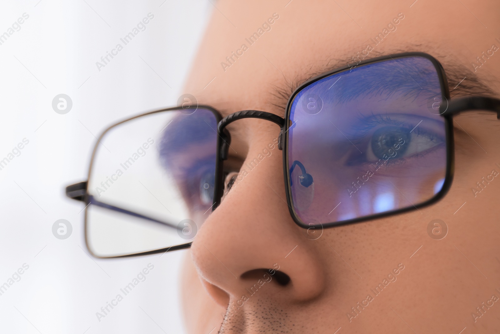 Photo of Man wearing glasses on light background, closeup