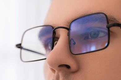 Man wearing glasses on light background, closeup