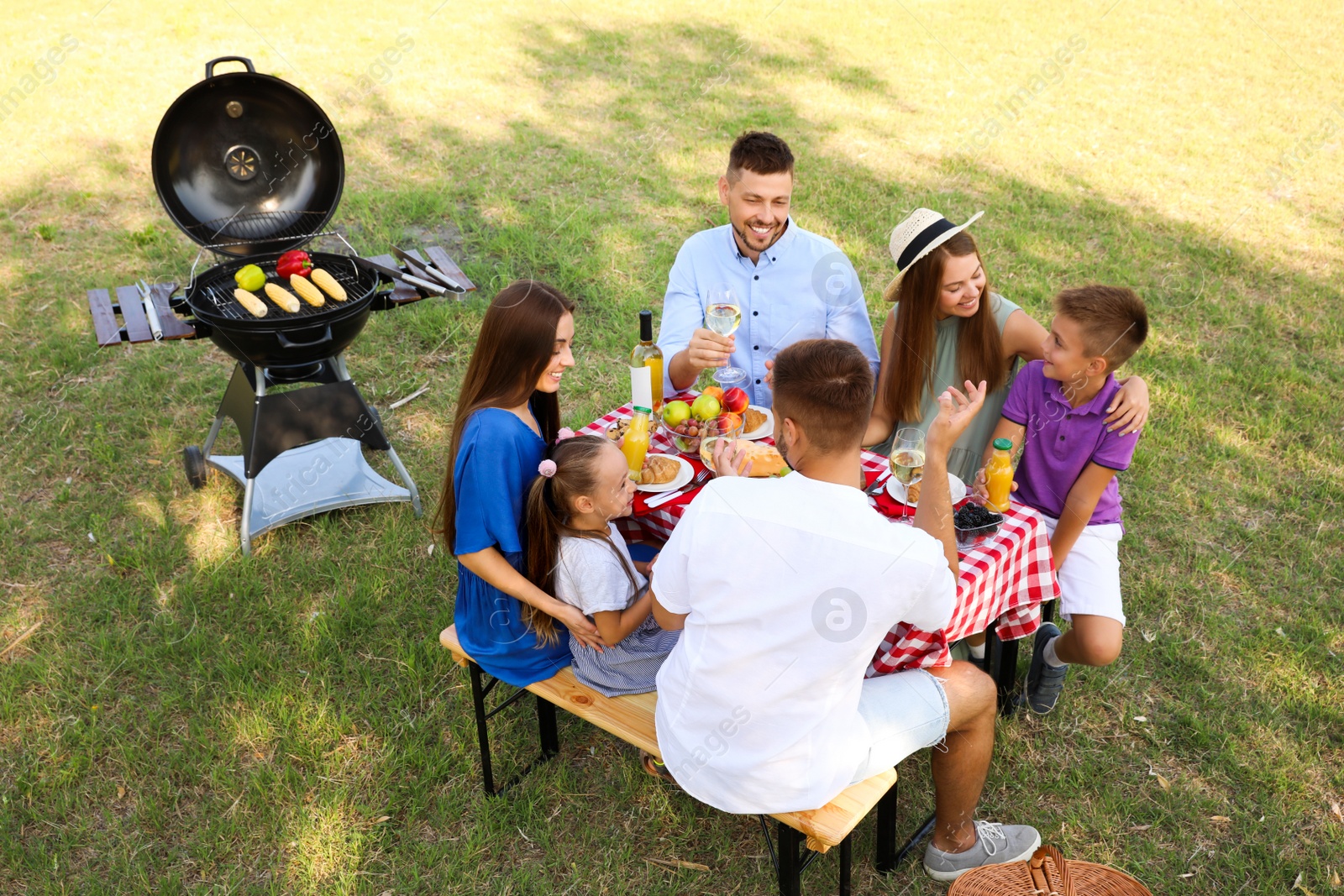 Photo of Happy families with little children having picnic in park