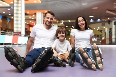 Happy family spending time at roller skating rink