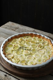 Photo of Freshly baked leek pie on old wooden table